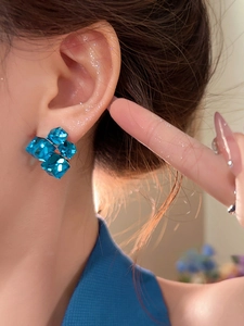 Close-up of blue crystal geometric square earrings worn on model for a trendy look