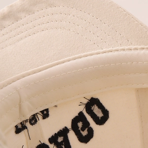 Detail of premium cotton twill fabric with black letter embroidery and fine stitching on cap