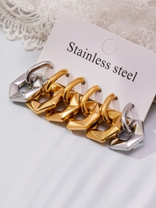 Detail of three pairs of geometric hexagonal stainless steel earrings in gold and silver
