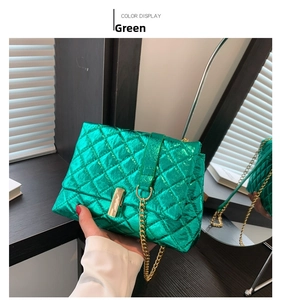 Close-up of green quilted metallic chain bag with gold lock and mirrored reflection