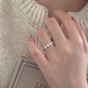 Detailed view of a 925 sterling silver leaf ring worn against a cozy knit background