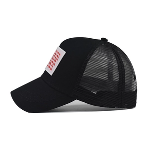 Vista laterale del cappello trucker nero con toppa a motivo di pesci rossi sul pannello frontale