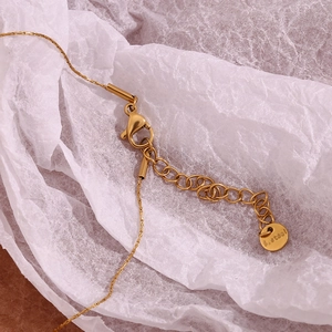 Detailed macro view of gold plated stainless steel necklace lobster clasp and extender chain