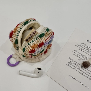 Close-up of colorful handmade knitted earphone case with zipper and purple clip