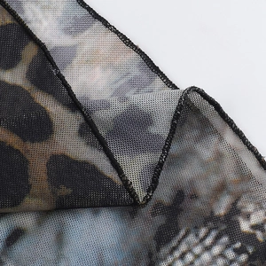 Détail macro du tissu en maille transparente à imprimé léopard et bords à volants