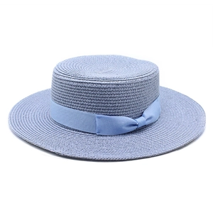 Detail of light blue straw boater hat featuring fine weave and a matching grosgrain bow