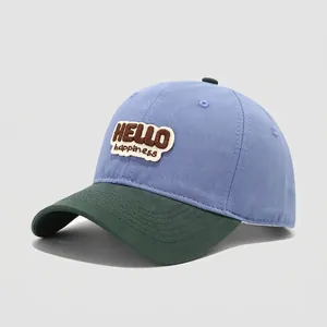 Detail of HELLO happiness embroidery on blue and green cotton baseball cap for kids