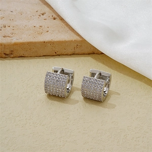 Detail of silver hoop earrings with pave cubic zirconia on silk and stone base