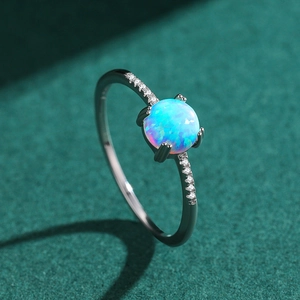 Elegant S925 sterling silver opal ring with side diamonds on a dark green background