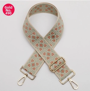Detail of bohemian geometric wide bag strap with golden metal swivel hooks and buckles