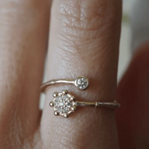 Macro view of adjustable rose gold ring with crystal flower and single stone detail