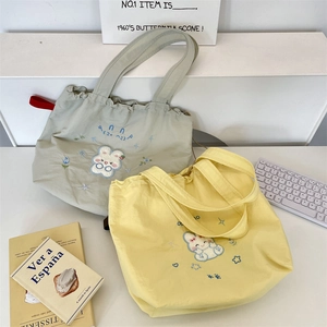 Detail of the embroidery pattern and drawstring closure on the casual tote bag