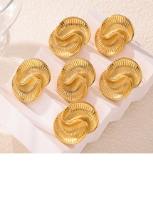 Detailed view of golden spiral textured drop earrings on geometric display stand
