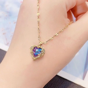 Close-up of heart-shaped blue-purple gradient crystal necklace with gold vintage edging