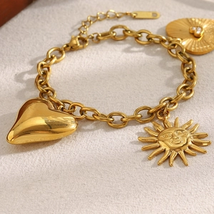 18K gold plated stainless steel sun and heart pendant chain bracelet on stone surface