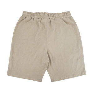 Close-up of the beige linen cotton fabric texture and elastic waistband on men's casual shorts