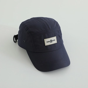 Detail of dark blue five-panel camper hat with a woven Change bear patch and metal eyelets