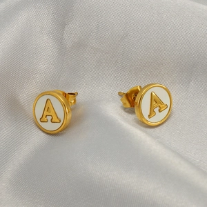 Elegant gold stainless steel letter A stud earrings with white enamel on silk fabric