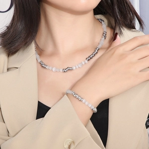 Gros plan sur l'ensemble collier et bracelet perles argentées et pierres d'opale blanche
