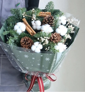 Close-up of Christmas bouquet with pine needles, cotton, pine cones, and cinnamon sticks