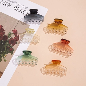 Flat lay of six gradient acetate hair claws in various colors on a stylish background