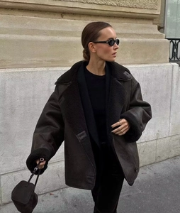 Detailed close-up of dark brown faux shearling jacket featuring lapel collar and leather texture