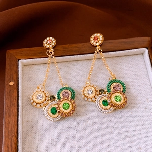 Detailed close-up of retro tassel earrings with colorful rhinestones on vintage linen