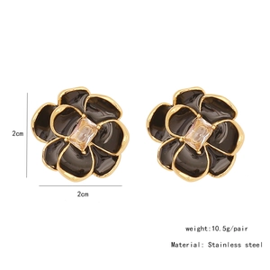 Detail view of 2cm black floral earrings with gold edges and weight specifications