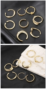 Flat lay of 8 gold minimalist open rings with bamboo and spiral textures on black silk