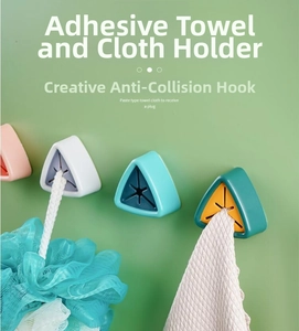 Detail of four colorful wall-mounted towel plugs with silicone cross openings for towels