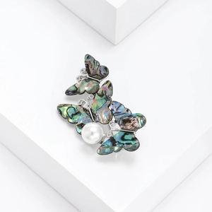 Elegant butterfly brooch with iridescent abalone shell wings and a white center pearl