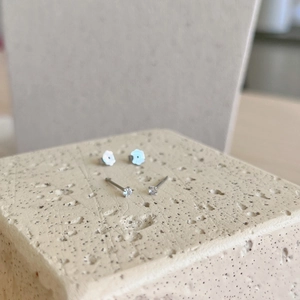 Detailed macro view of S925 sterling silver stud earrings with zirconia and floral backs