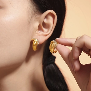 Polished 18k gold plated crescent earrings with sparkling pavé zircons on model
