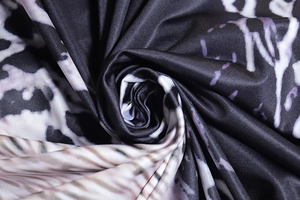 Close-up of abstract snake print fabric with purple accents and premium pleated texture