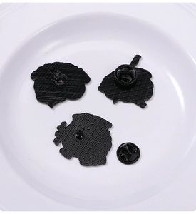 Detail view of the textured metal back and black rubber clutch of heart and brain enamel pins