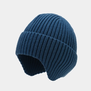 Detailed close-up of dark blue ribbed knit beanie featuring warm ear flap design