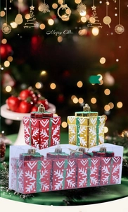 Detail of red and gold Christmas gift box ornaments with hand-painted white snowflakes