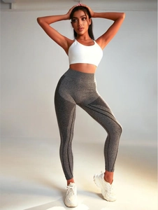 Detailed side view of high-waisted seamless yoga pants with black streamlined texture patterns
