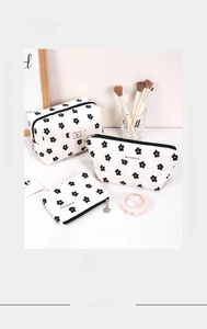 Three-piece quilted makeup bag set featuring cute black floral patterns and sturdy zippers