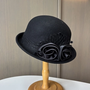 Close-up of black wool felt cloche hat with satin roses and delicate mesh veil detail