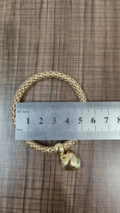 Detailed view of golden popcorn chain bracelet with heart pendant and size measurement
