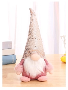 Close-up of pink sequined gnome plush with white beard on a warm wooden tabletop