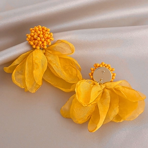 Detail view of yellow lace flower earrings with beaded centers and silver needle studs