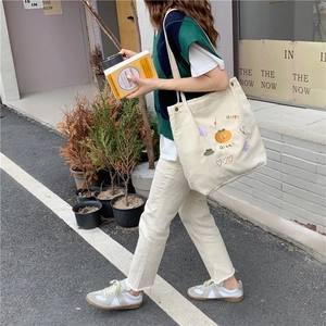 Détail de la broderie mignonne de fruits et arc-en-ciel sur sac cabas en velours côtelé