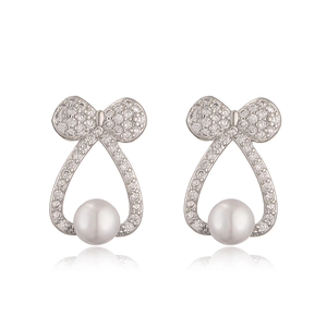 Orecchini a fiocco in argento con zirconi e perle a goccia su sfondo bianco pulito