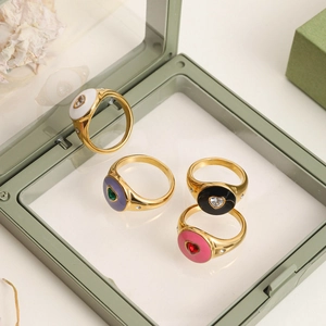 Top view of gold-plated stainless steel rings with colorful enamel hearts in a jewelry box