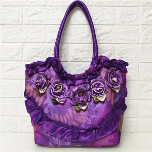 Detail of purple satin tote bag featuring handcrafted floral texture and ruffled edge