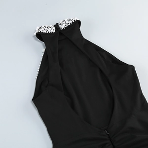 Detail of black halter neck dress with pearl and rhinestone embellishments on the open back
