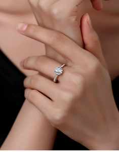 Macro shot of 1 carat round moissanite ring showing 6-prong silver setting and side accents
