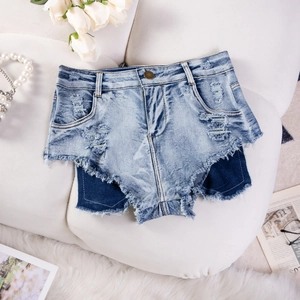 Dettaglio di shorts in denim a vita alta con design patchwork e orli sfrangiati